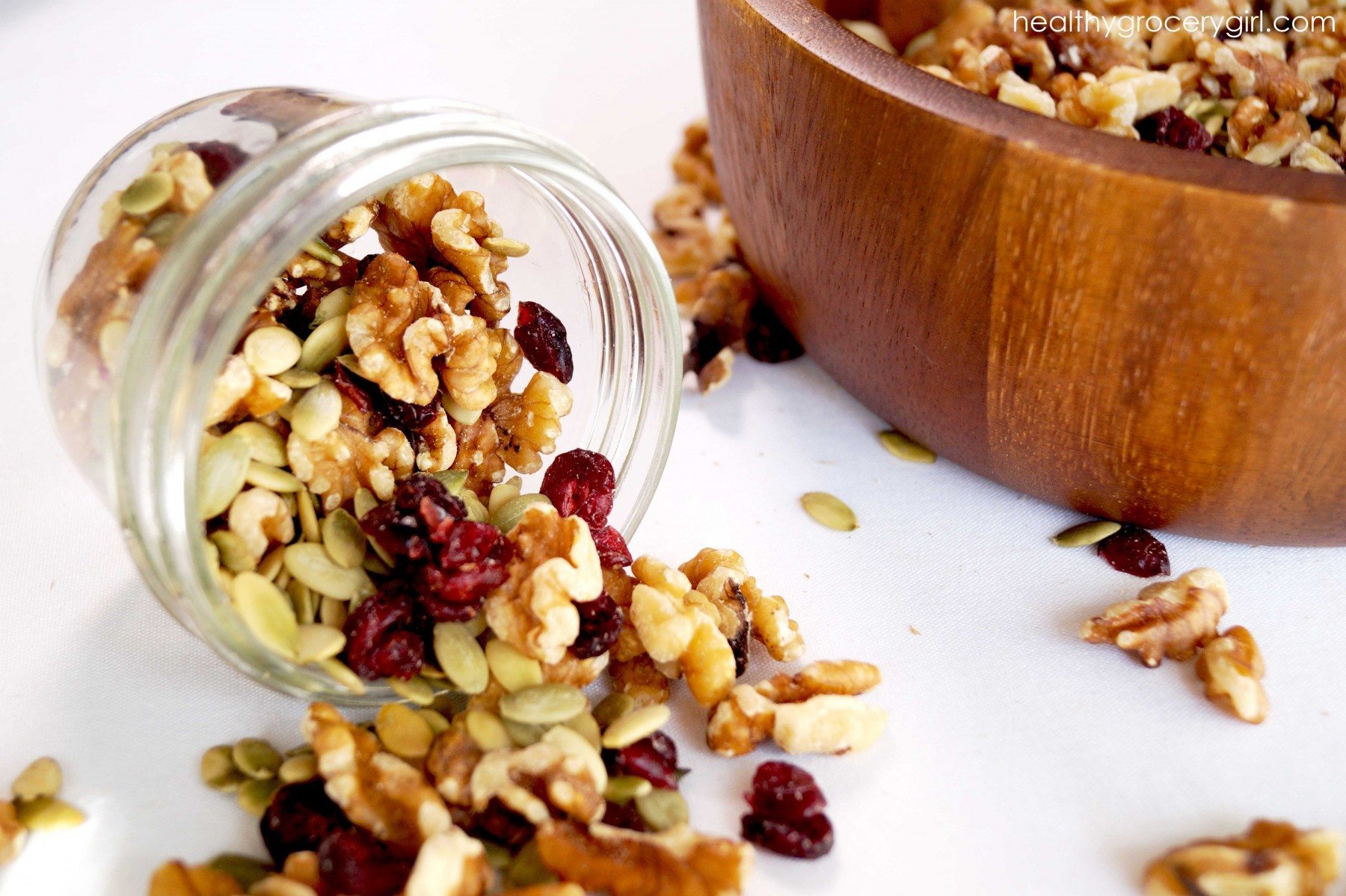 Fall trail mix spilling out featuring walnuts and dried berries
