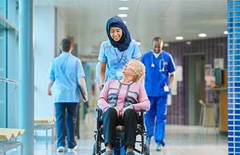 Volunteer Pushing Woman in Wheelchair