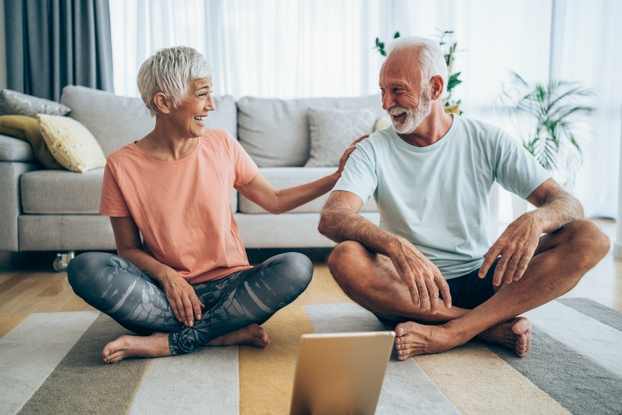 An older couple practicing meditative yoga