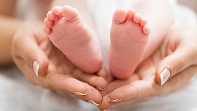 A pair of hands holding a baby's feet