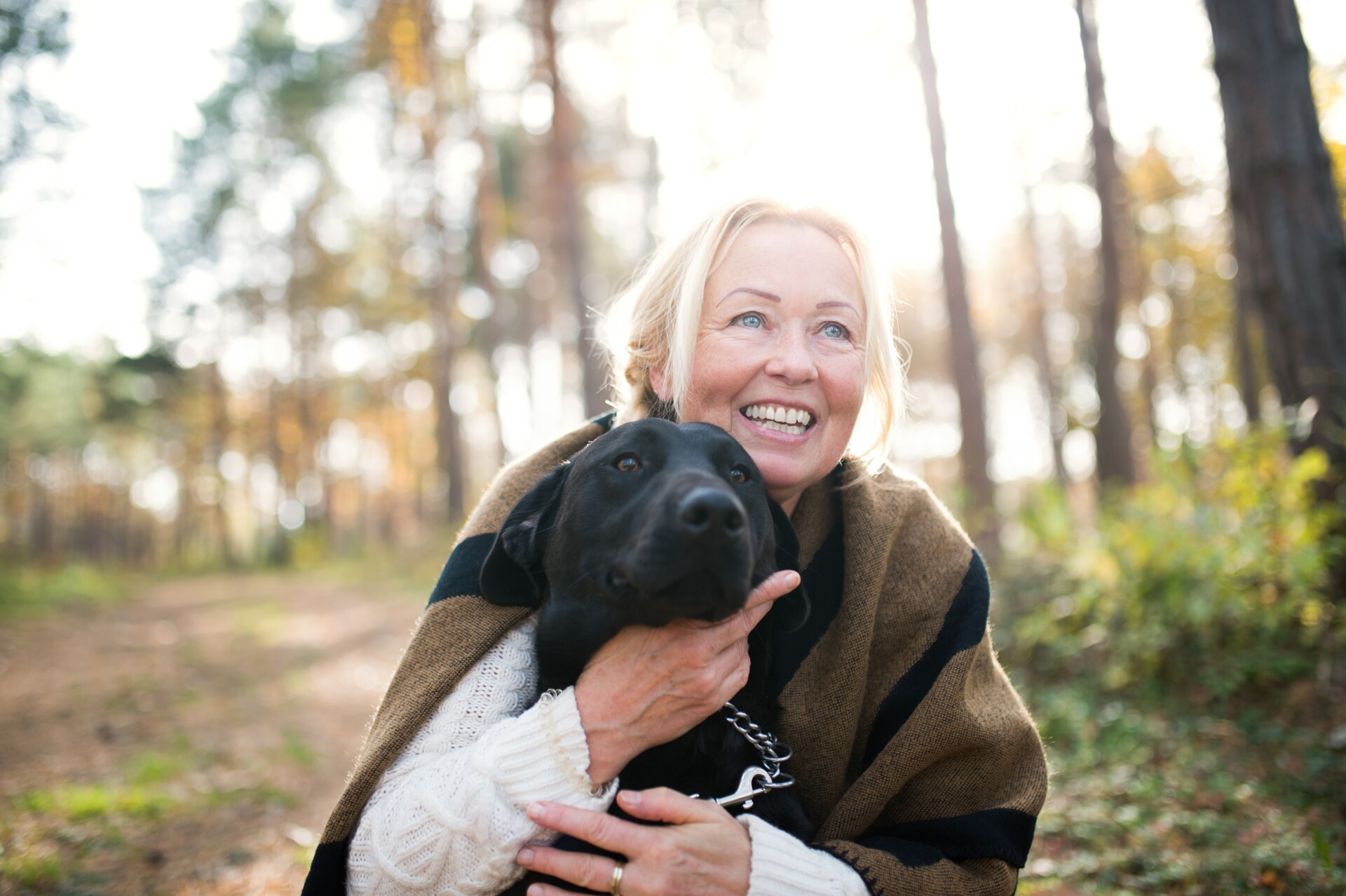 Woman smiling while hugging her dog
