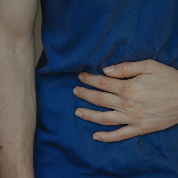 Someone holding their stomach in pain