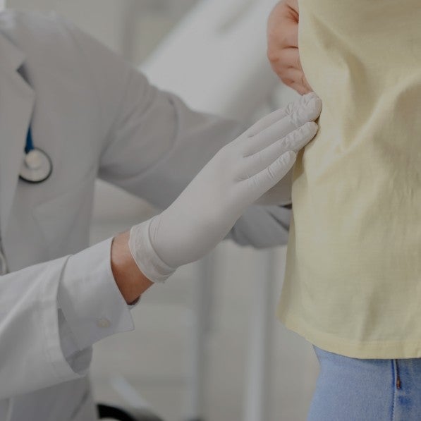 A doctor's gloved hand over a patient's stomach