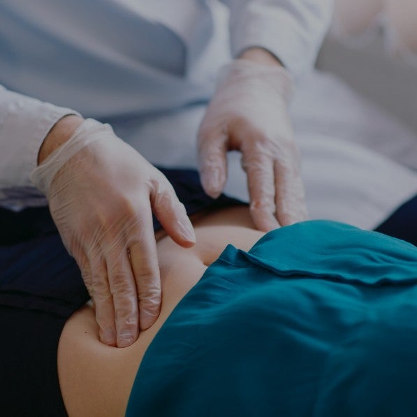A person's hands massaging another person's belly